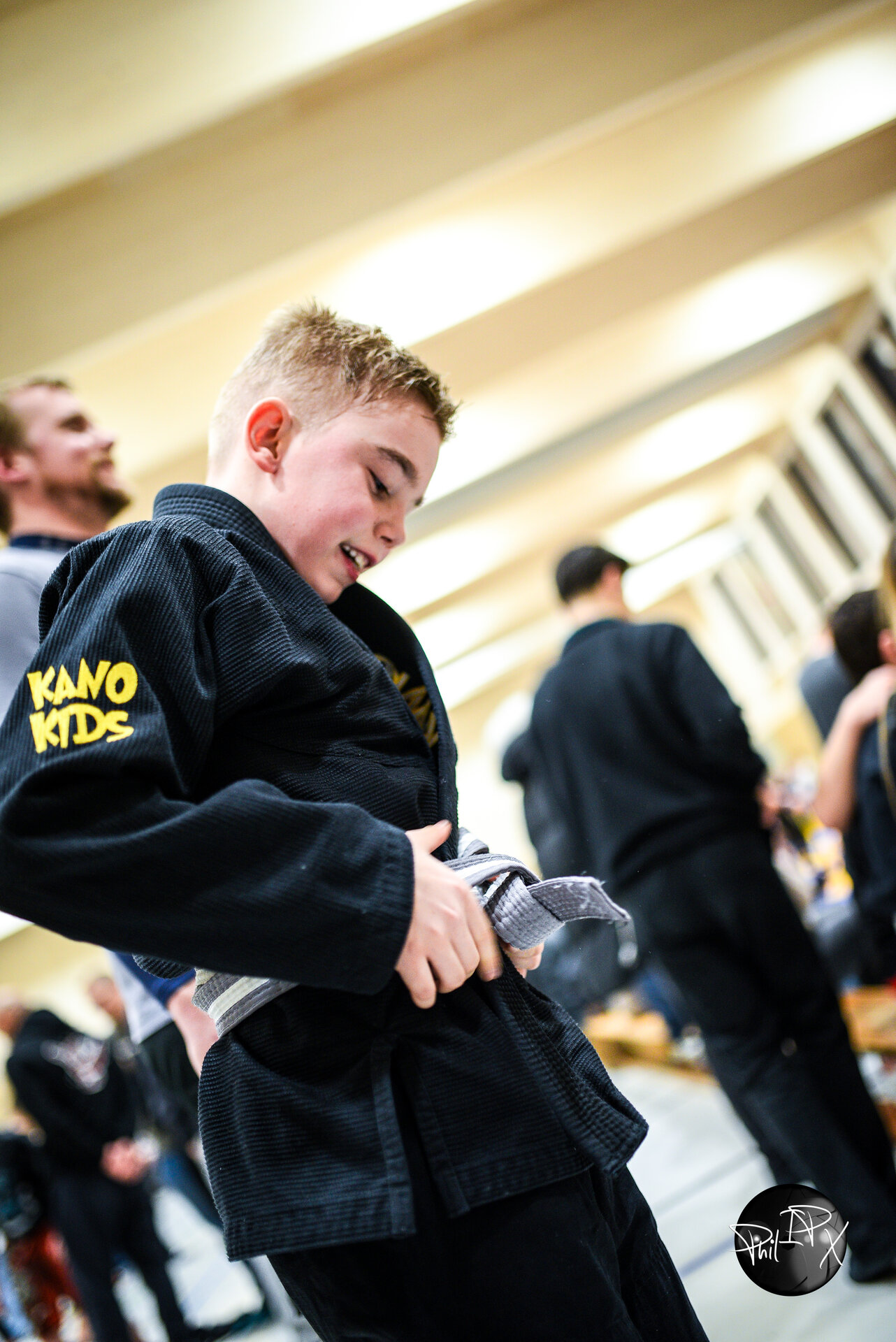 Child tying their belt before a tournament