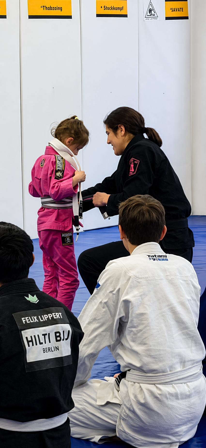 Mini getting their belt tied at a tournament